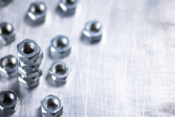 Working tool. Metal nuts on the table. On a gray background. High quality photo - Photo, Image