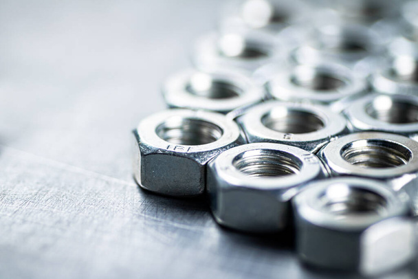 Working tool. Metal nuts on the table. On a gray background. High quality photo - Valokuva, kuva