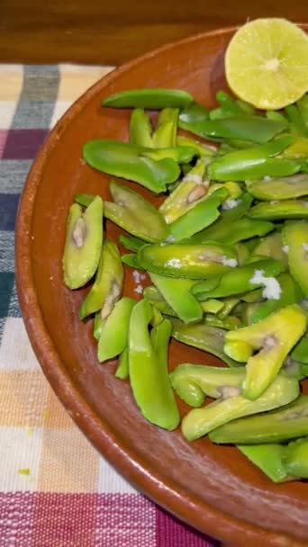 Semena Inga edulis, exotické ovoce podávané v hliněné míse s citronem a solí. běžně nazývané: guama, guaba, pacae nebo pacay - Záběry, video