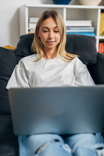 Front view of a young blond woman using a laptop. - Valokuva, kuva