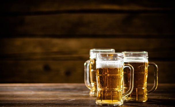 Glasses with fresh beer. On wooden background. - Zdjęcie, obraz