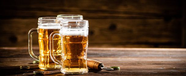 Glasses with fresh beer. On wooden background. - Photo, image