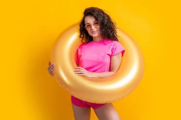 summer woman with inflatable ring in studio. summer woman with inflatable ring on background. photo of summer woman with inflatable ring. summer woman with inflatable ring isolated on yellow. - Photo, Image