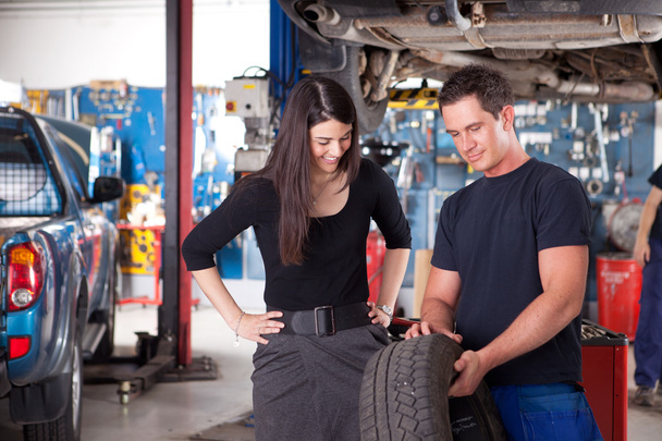 Mechanic Showing Tire to Woman Customer - Foto, Imagen