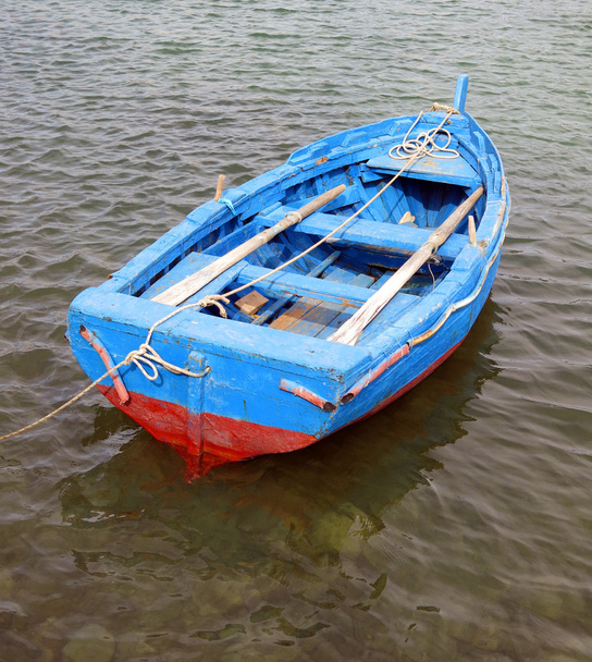 blue and red boat in the middle of the ocean - Фото, изображение