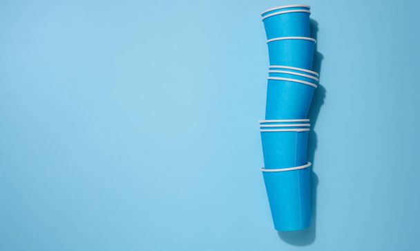 Tasses jetables bleues pour café et thé sur fond beige, vue de dessus - Photo, image