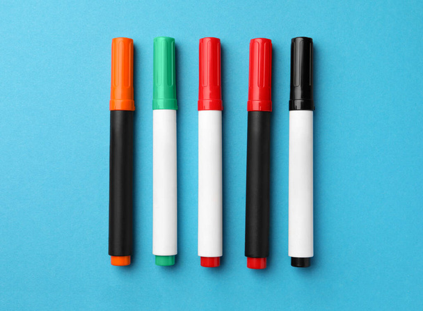 Bright color markers on light blue background, flat lay - Foto, immagini