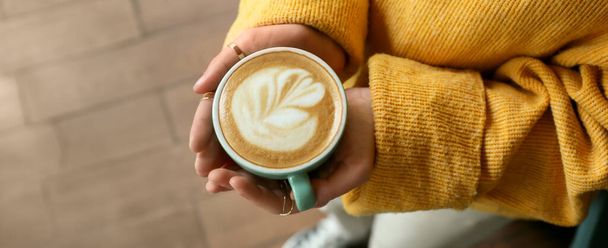 Kobieta z filiżanką gorącego cappuccino w kawiarni, zbliżenie. Baner do projektowania - Zdjęcie, obraz