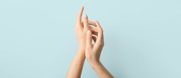 Vrouwelijke handen met mooie manicure op lichte achtergrond - Foto, afbeelding