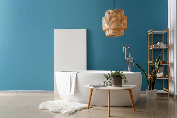 Sisätilojen kylpyhuone kylpyammeella ja huonekasvi sohvapöytä - Valokuva, kuva