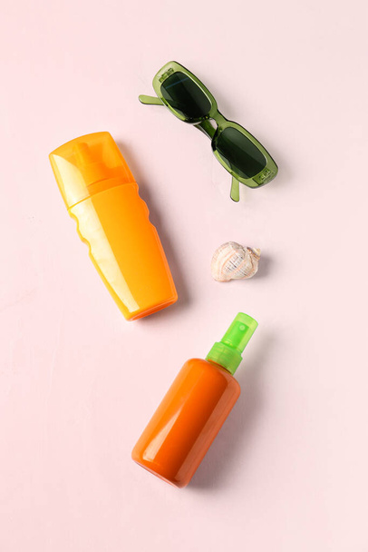 Μπουκάλια αντηλιακή κρέμα και γυαλιά ηλίου σε λευκό φόντο - Φωτογραφία, εικόνα