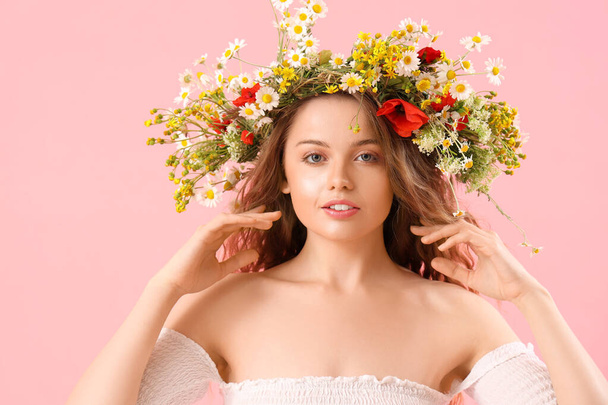 Beautiful young woman in flower wreath on pink background. Summer solstice - Foto, Imagen