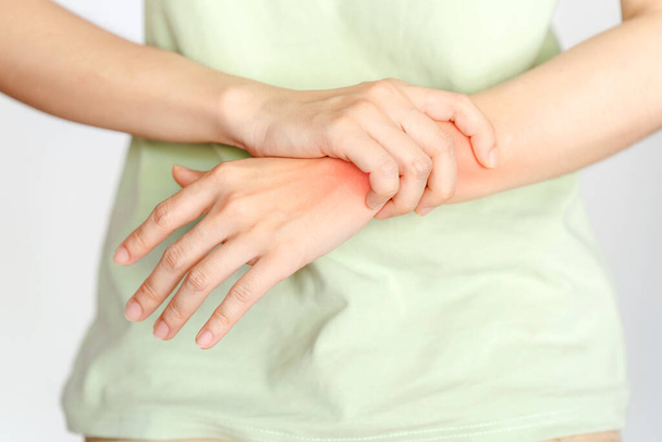 Μια γυναίκα αγγίζει τον καρπό της λόγω τραυματισμού ή ρευματοειδούς αρθρίτιδας. - Φωτογραφία, εικόνα