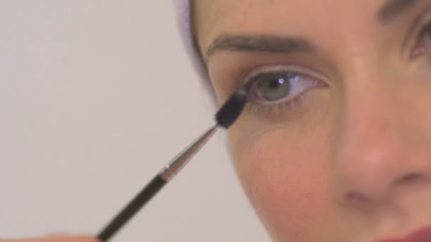 Woman applying mascara - Filmati, video