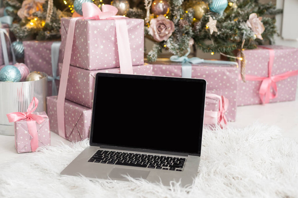computer portatile e albero di Natale sullo sfondo. - Foto, immagini