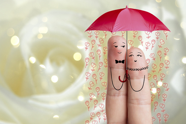 Концептуальное искусство пальца. Любовники обнимают и держат красный зонтик с падающими цветами. Образ запаса
 - Фото, изображение
