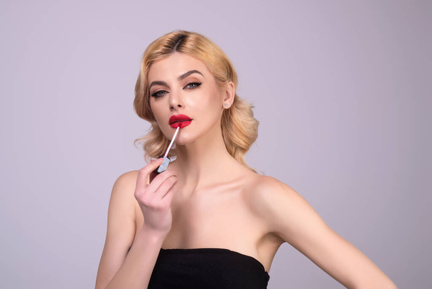 Photo of shirtless woman posing with lipstick, isolated studio background. Beautiful woman holding with naked shoulder hold lipstick. Sexy girl using lipstick - Φωτογραφία, εικόνα