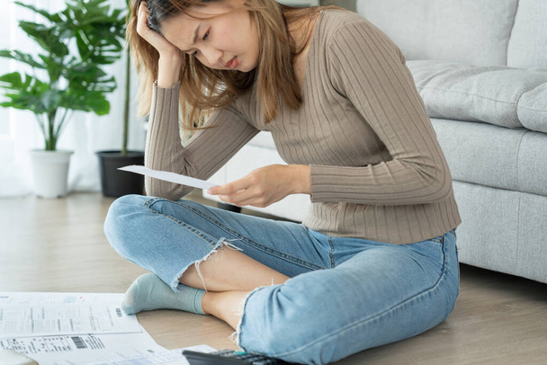 Stressed and headache asian woman with large bills or invoices no money to pay to expenses and credit card debt. shortage, Financial problems, mortgage, loan, bankruptcy, bankrupt, poor, empty wallet - Fotoğraf, Görsel
