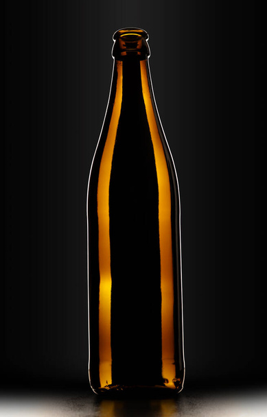 Bottle of beer in drawing light on black background. - Fotoğraf, Görsel
