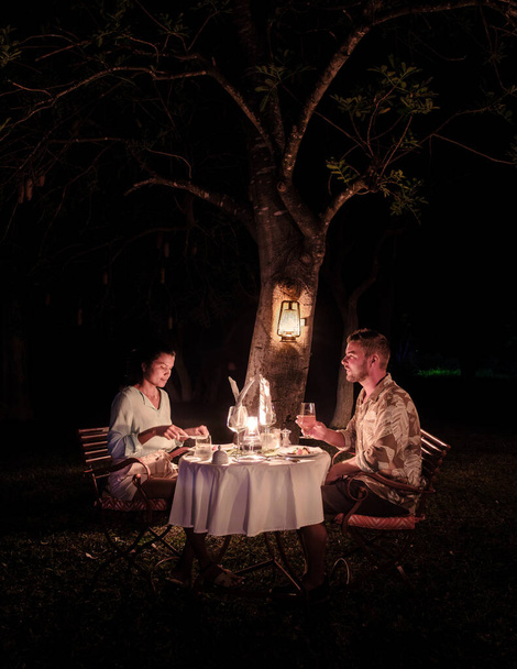 couple men and romantic woman having dinner on a luxury safari, in South Africa l, a luxury safari lodge in the bush of a Game reserve - Zdjęcie, obraz
