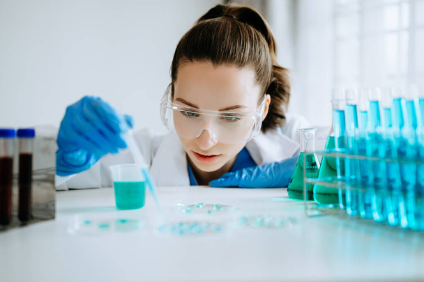 Modern medical research laboratory. female scientist working with micro pipettes analyzing biochemical samples, advanced science chemical laboratory for medicine.  - Foto, imagen