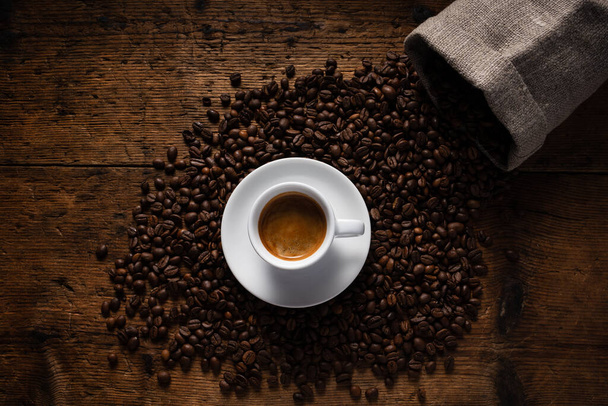 vista superior xícara de café em cima de grãos de café. - Foto, Imagem