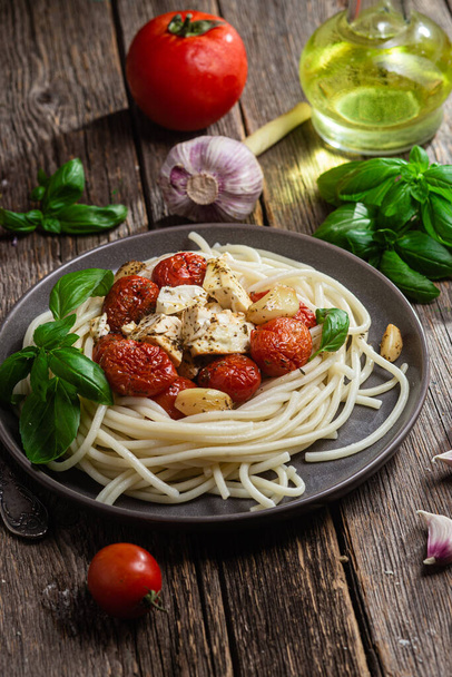 Italian pasta. Spaghetti with baked feta cheese and tomatoes in a bowl - Photo, Image