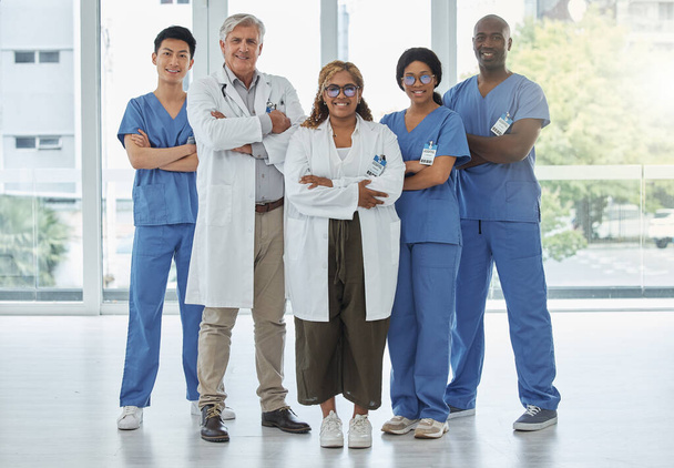 Лидерский портрет, врачи и медсестры со скрещенными руками в больнице. Лицо, командная работа и уверенные в себе медицинские работники, групповые или счастливые хирурги с сотрудничеством в области здравоохранения. - Фото, изображение