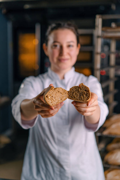 panadero mostrando corte caliente recién horneado crujiente pan hinchado panadería panadería producción de hornear cocina profesional - Foto, imagen