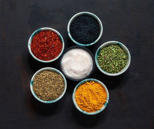 Traditional oriental spices in ceramic bowls.black cumin seed,ground red pepper,dried mint,himalayan salt. - Foto, immagini