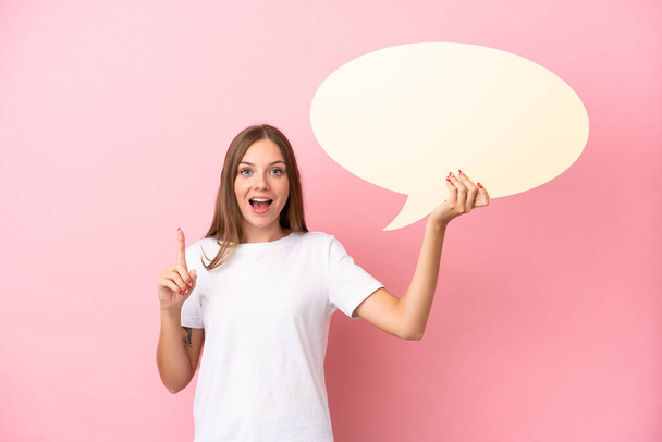 Young Lithuanian woman isolated on pink background holding an empty speech bubble with surprised expression - Фото, изображение