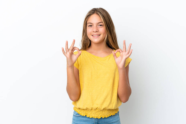 Pequena menina caucasiana isolado no fundo branco mostrando sinal ok com duas mãos - Foto, Imagem