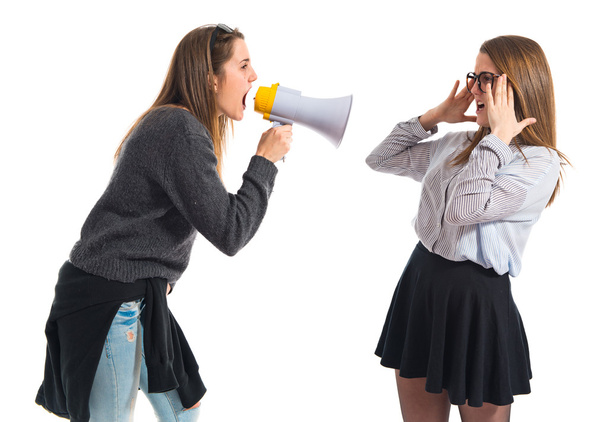 Girl shouting at her sister by megaphone   - Foto, imagen