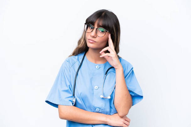 Молодая кавказская медсестра изолирована на белом фоне, думая об идее - Фото, изображение