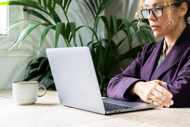 Poważny szef przedsiębiorca businesswoman patrząc poważnie komputer w biurze w czasie pracy. Pewne siebie kobiety w pracy z laptopem obserwujące wyświetlanie pewnie. Portret biznesmena - Zdjęcie, obraz