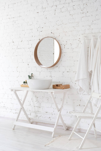 μοντέρνο minimal στυλ μπάνιο, νεροχύτης, καθρέφτης και το τραπέζι σε λευκό φόντο τούβλο τοίχο - Φωτογραφία, εικόνα