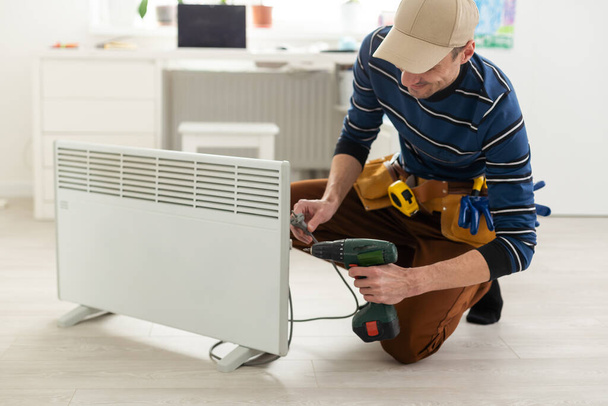 Smart heater convector. the master repairs the electric heater. - Foto, Imagem