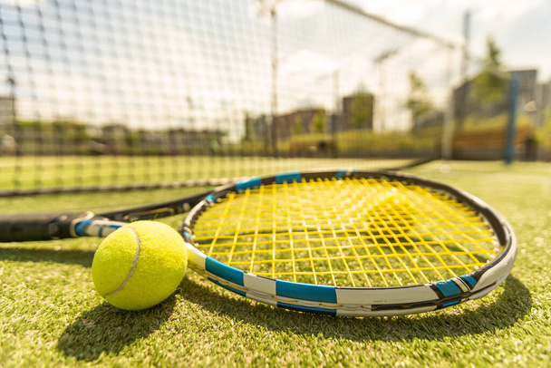 tennis racket with a tennis ball on a tennis court. - Fotoğraf, Görsel