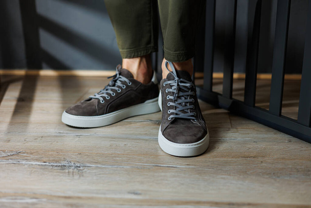 Close-up of male legs in pants and gray casual sneakers. Men's leather shoes. Collection of men's stylish summer shoes - Foto, Imagen