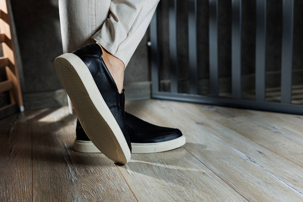 Pernas masculinas em sapatos de couro. Sapatos pretos masculinos confortáveis sem atacadores. Mocassins masculinos casuais - Foto, Imagem