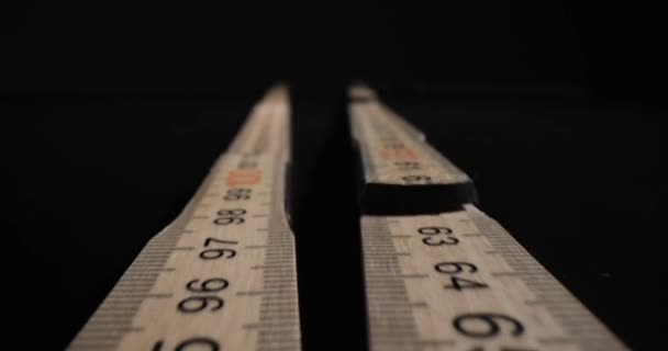 Régua de madeira longa com dígitos e linhas para medir o comprimento. Ferramenta de centímetro preparada para medição em fundo preto. Conceito de instrumento de medição de construção - Filmagem, Vídeo