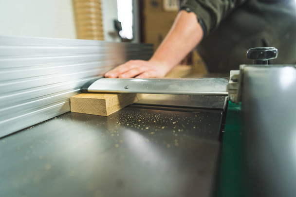 primer plano de un trozo de madera que entra en el sistema de vacío en el taller de carpintería. Foto de alta calidad - Foto, Imagen