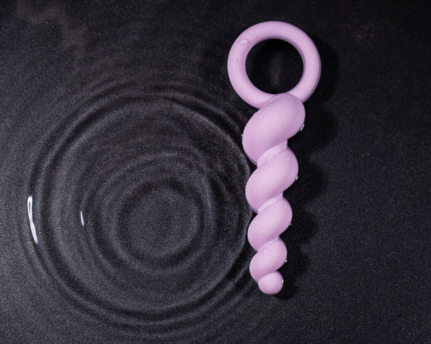 Lilac anal beads in water on a black background - Fotografie, Obrázek