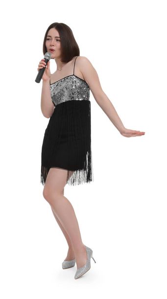 Beautiful young woman with microphone singing on white background - Fotó, kép