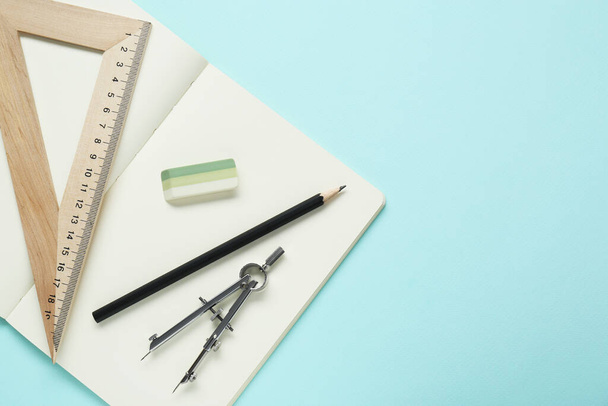 Different rulers, pencil, compass and notebook on turquoise background, flat lay. Space for text - Foto, afbeelding
