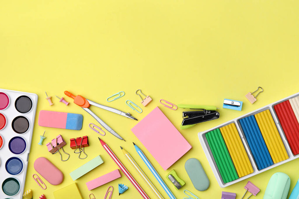 Flat lay composition with different school stationery on pale yellow background, space for text. Back to school - Фото, изображение