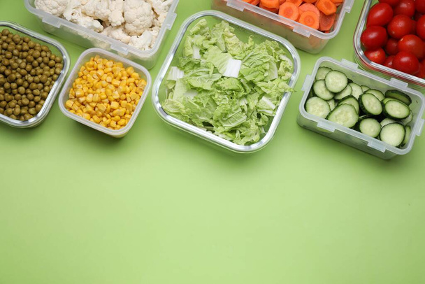 Plastic and glass containers with different fresh products on light green background, flat lay. Space for text - Foto, Bild