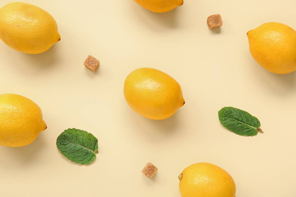 Reife Zitronen mit Minze und braunem Zucker auf hellgelbem Hintergrund - Foto, Bild