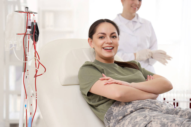 Mujer soldado donando sangre en la clínica - Foto, Imagen