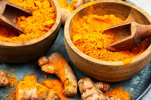 Dried turmeric roots in a wooden bowl. Turmeric spice. - Photo, Image